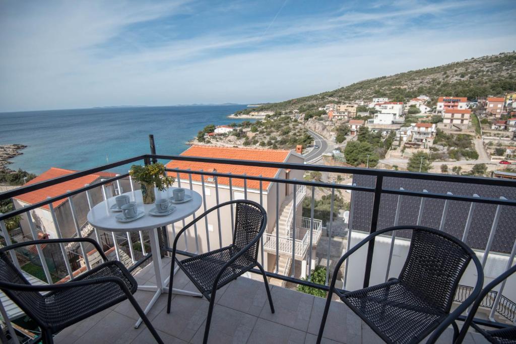 balcón con mesa, sillas y vistas al océano en Apartment Miro, en Dolac
