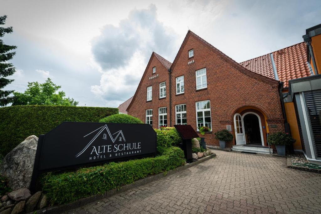 a sign in front of a brick building at Hotel & Restaurant Alte Schule in Siek