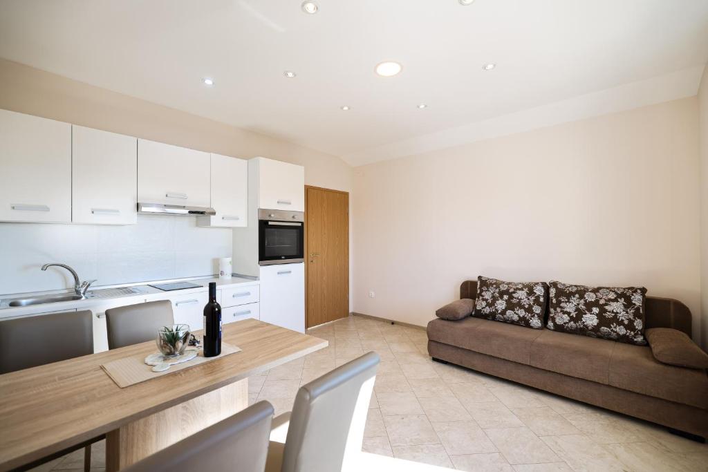 a kitchen and living room with a couch and a table at Apartments Anka with Seaview in Vrsi