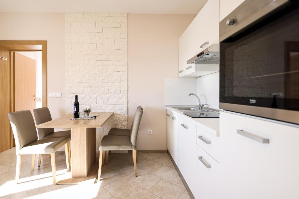 a kitchen with a table and chairs and a sink at Apartments Anka with Seaview in Vrsi