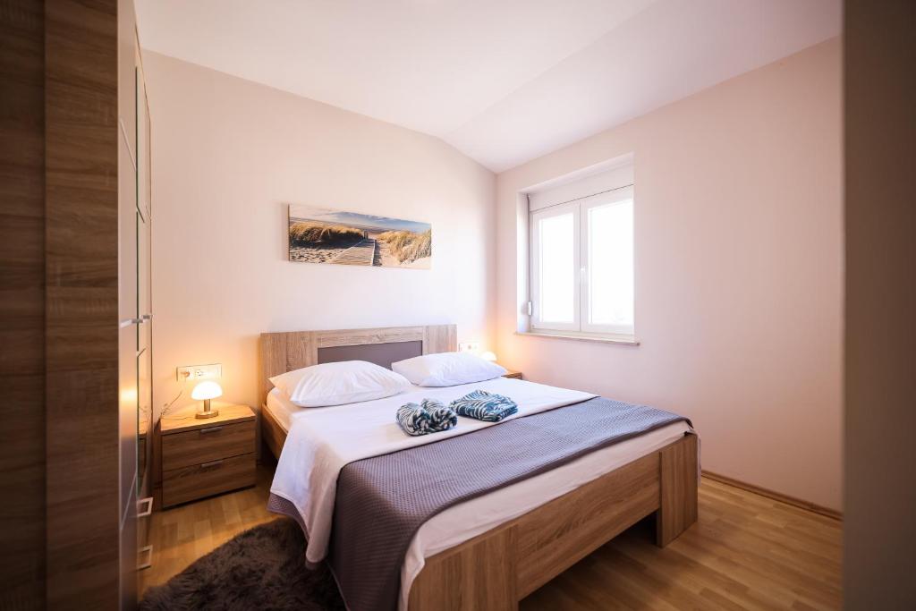 - une chambre avec un lit et une fenêtre dans l'établissement Apartments Anka with Seaview, à Vrsi