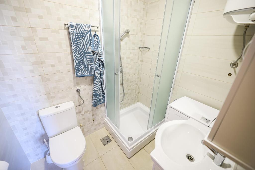 a bathroom with a shower and a toilet and a sink at Apartments Anka with Seaview in Vrsi