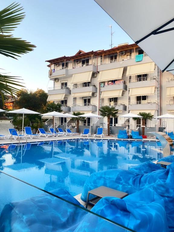 a swimming pool with blue chairs and a hotel at Hotel Beach Restaurant Fabio in Borsh