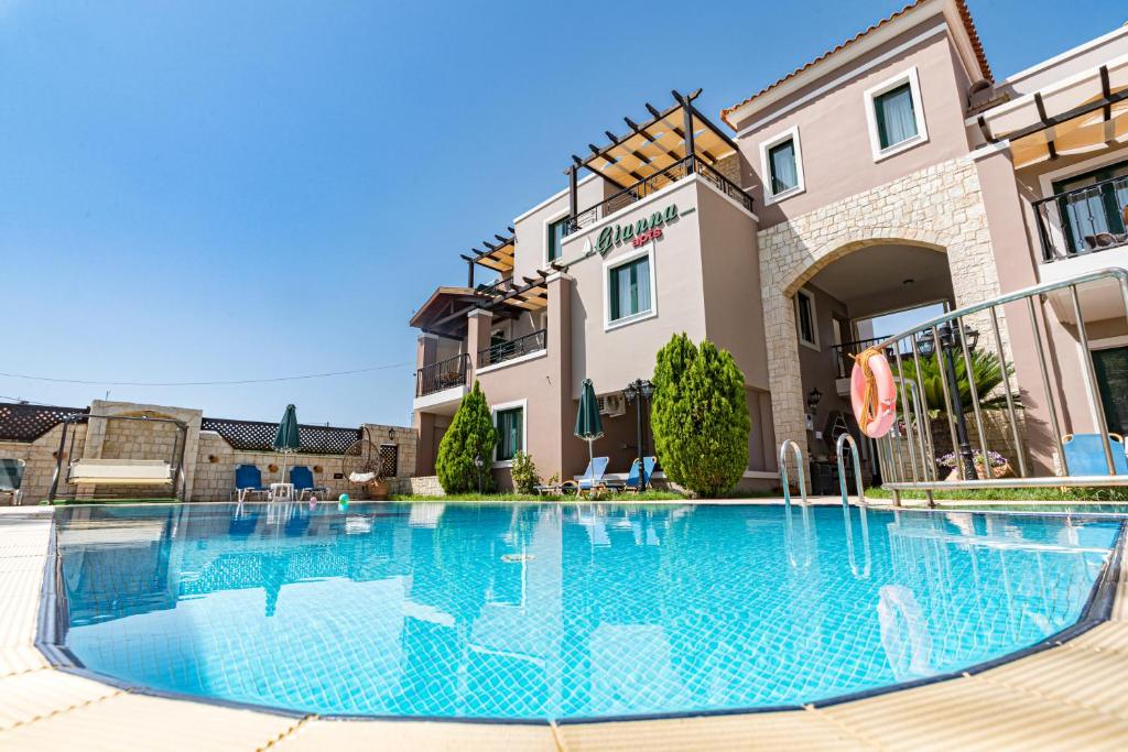 a large swimming pool in front of a building at Gianna Apartments in Almirida