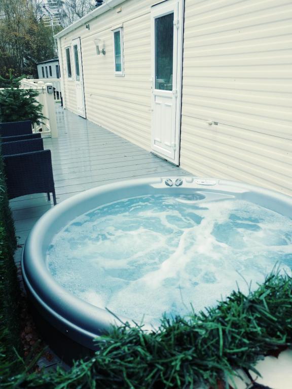 a jacuzzi tub sitting outside of a house at Len's Getaway Tattershall Lakes in Tattershall