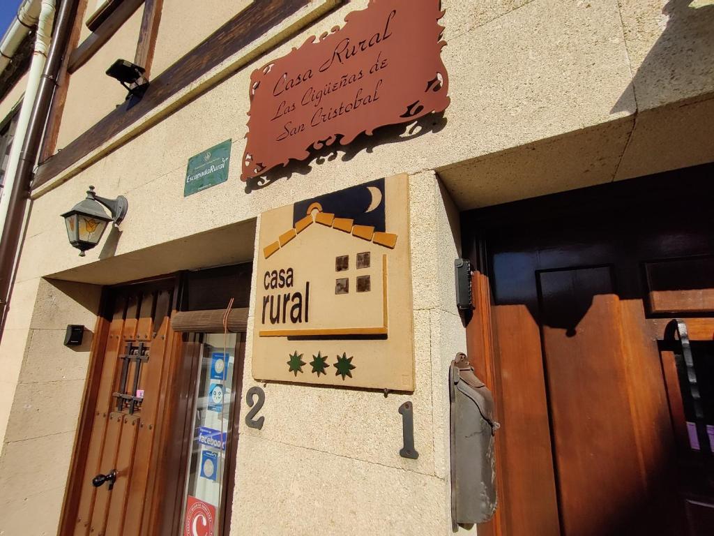 una señal en el lateral de un edificio en Las Cigüeñas de San Cristóbal, en San Cristóbal de Segovia