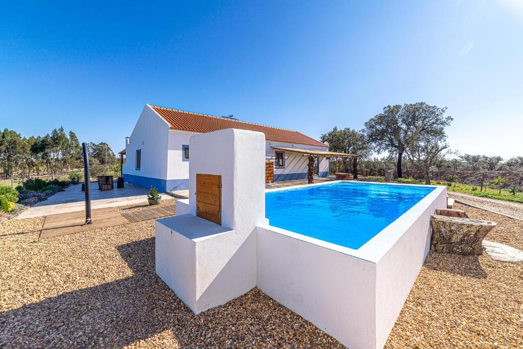 una casa con piscina frente a una casa en Villa Casanova en Melides