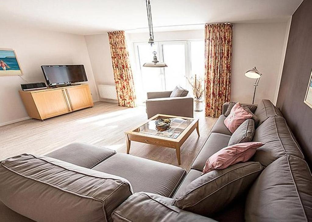 ein Wohnzimmer mit einem Sofa und einem Tisch in der Unterkunft Ferienwohnung Aalfänger in Breege