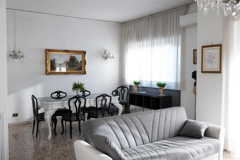uma sala de estar com um sofá e uma mesa com cadeiras em Oltremare Salerno Apartment em Salerno