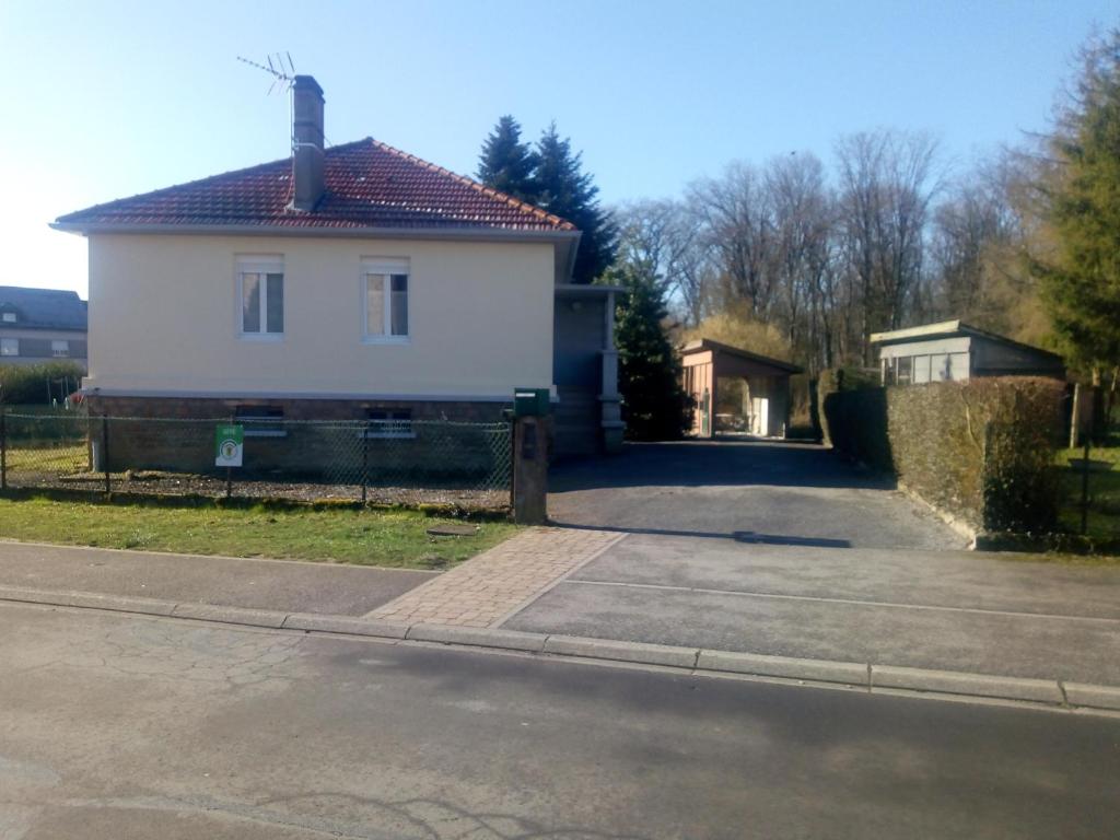 Ein weißes Haus an der Seite einer Straße in der Unterkunft La maison écologique in Batilly