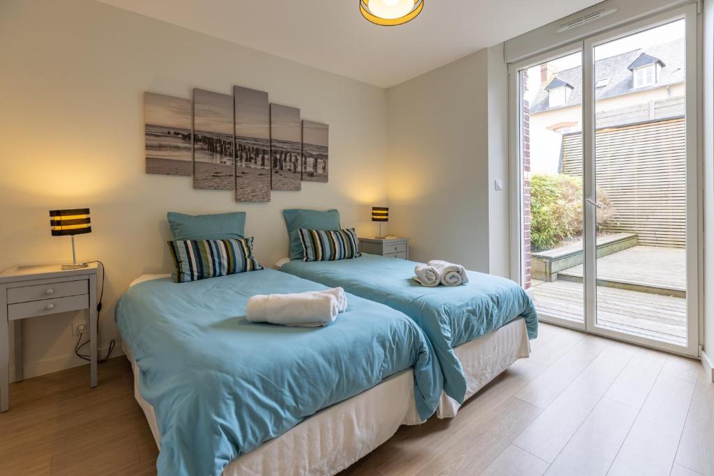 two beds in a bedroom with a window at Les Agîtés in Bain-de-Bretagne