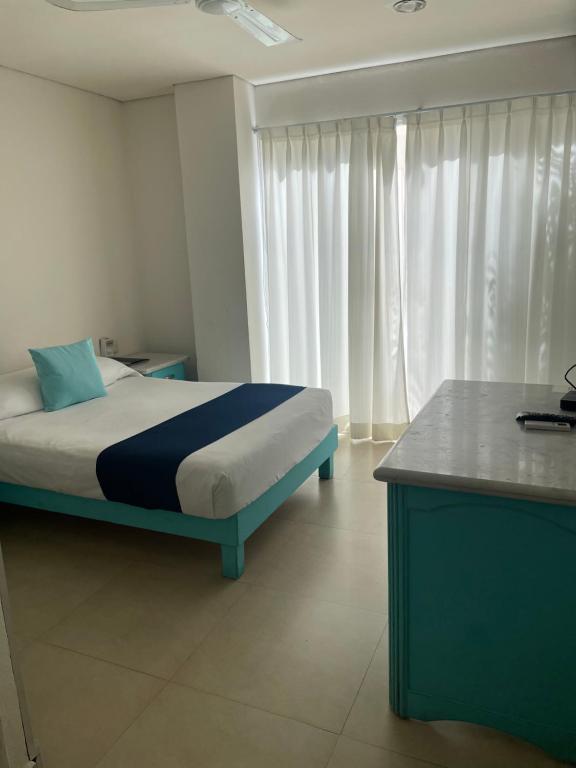 een slaapkamer met een bed, een bureau en gordijnen bij Luna Creciente in Santa Cruz Huatulco