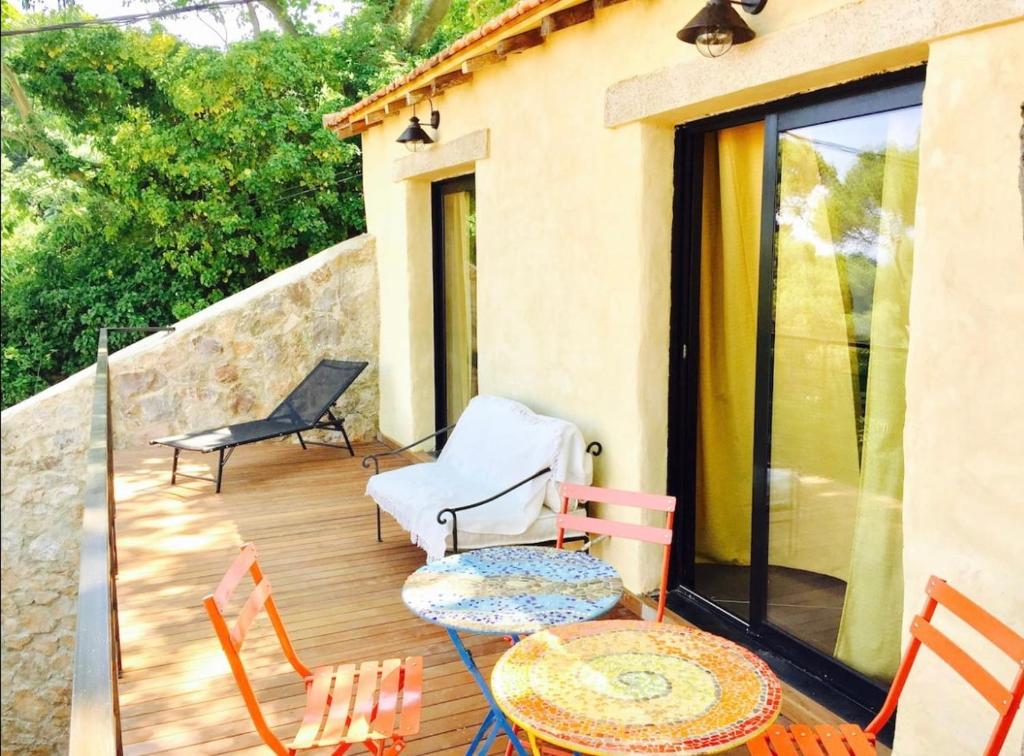 une terrasse en bois avec des chaises, une table et des chaises dans l'établissement Maison, centre ville, terrasse, parking, calme, à Sète