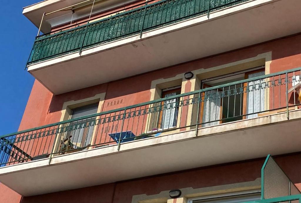 un edificio con un balcón con un perro. en Vacanze a Finale Ligure, en Finale Ligure