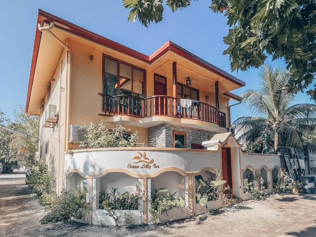 a house with a balcony on top of it at Ocean Lilly Inn in Hangnaameedhoo