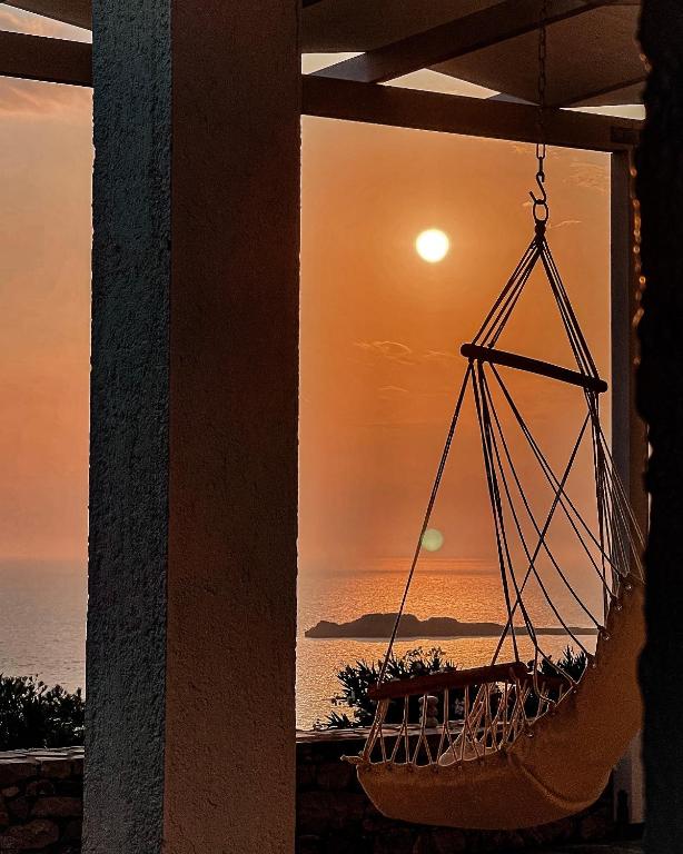 a hammock hanging from a porch with a sunset at Vanis House Sunset View Kythira in Kythira