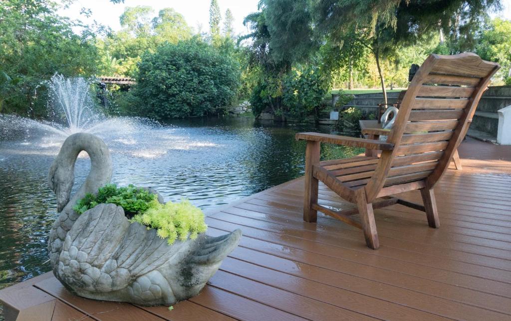 a statue of a swan and a chair on a wooden deck at Shangri-La Springs in Bonita Springs