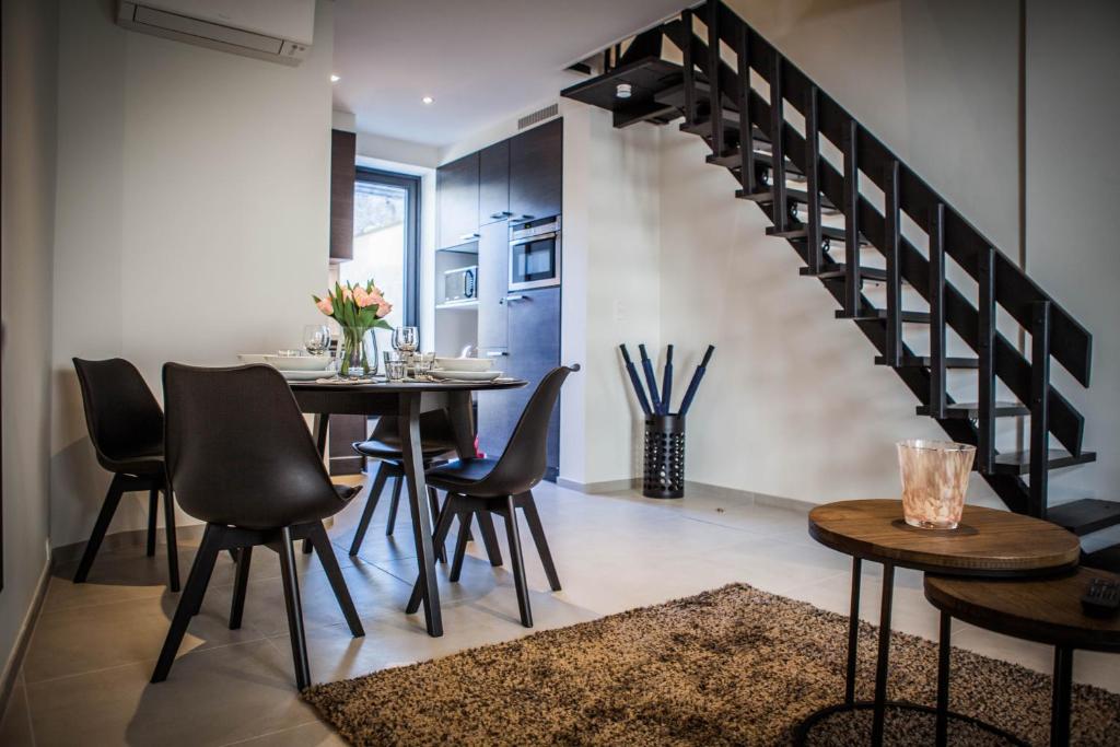 een eetkamer met een tafel en stoelen en een trap bij Huis ALNA 1 in Mechelen