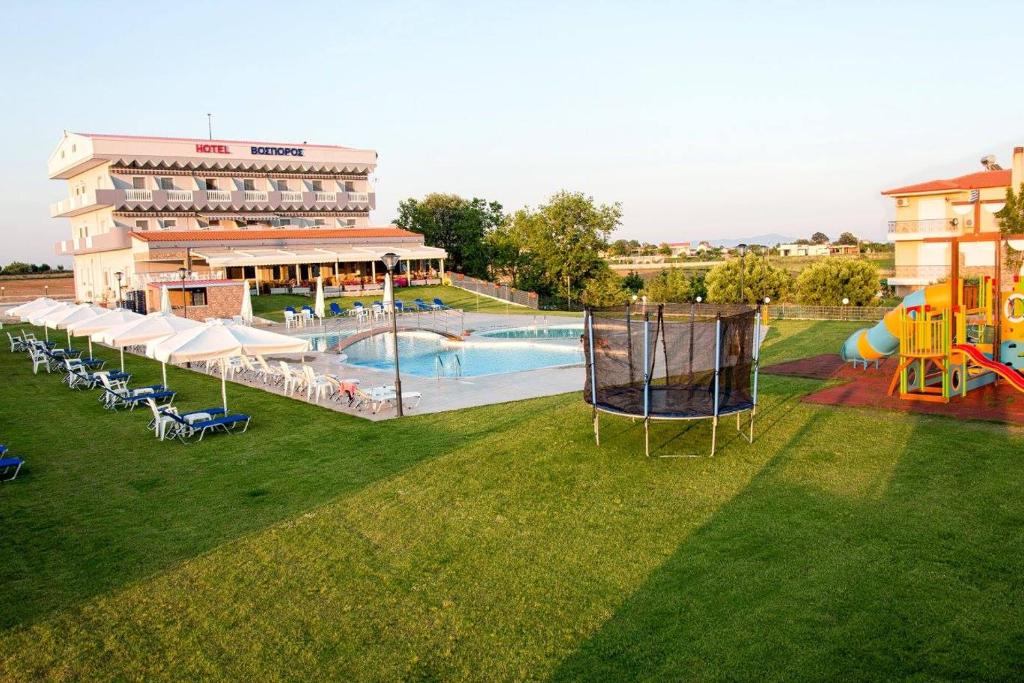 un hotel con una gran piscina y un edificio en Vosporos Hotel, en Komotiní