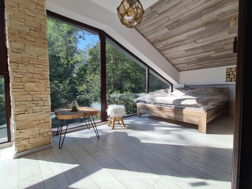 um quarto com uma cama e uma grande janela em Penthouse luxury Predeal View em Predeal
