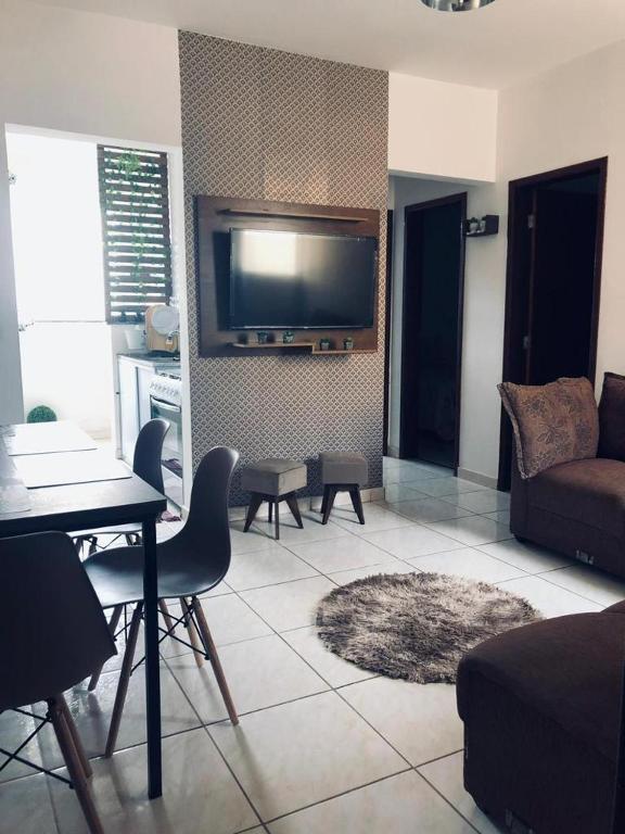 a living room with a couch and a tv on the wall at Apartamento 403 Bloco I - Condomínio dos lagos II in Capitólio