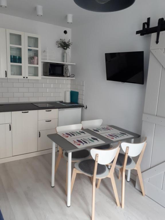 a kitchen with a table and two chairs at Apartament Pokoje U Franka in Jastarnia