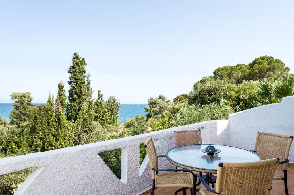 a table and chairs on a balcony overlooking the ocean at Koroni Village in Koroni