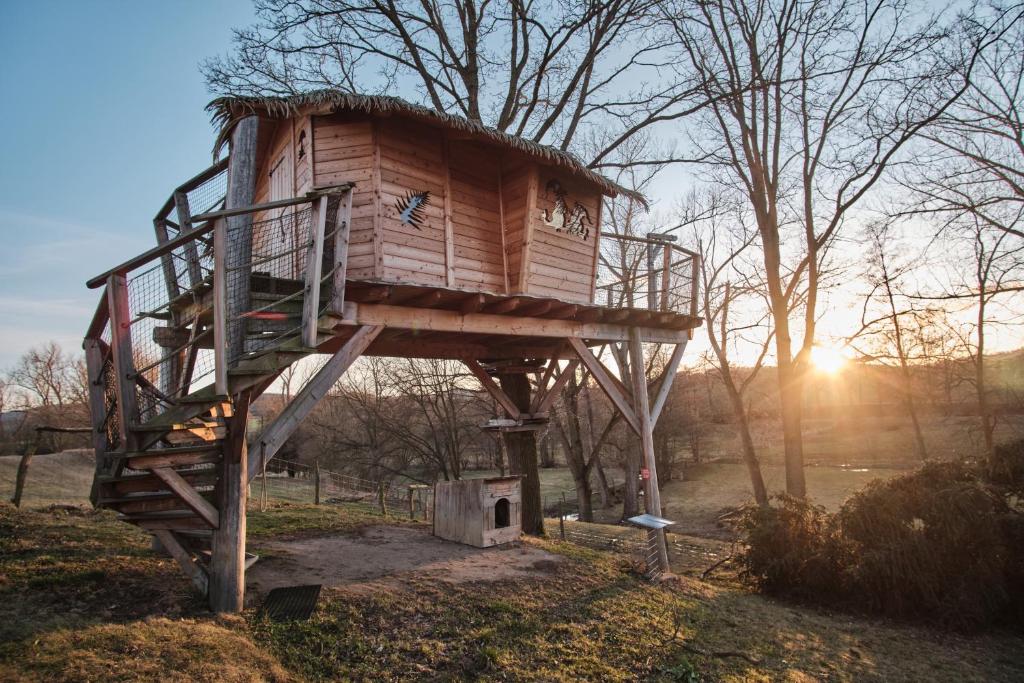 a tree house sitting in the middle of a field at Treehouse Křemílek in Jesenice