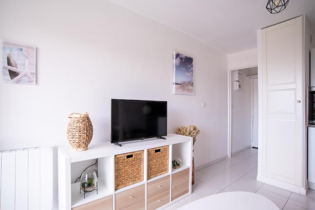 - un salon avec une télévision sur un meuble blanc dans l'établissement Nice Studio With Balcony At 7 Min From The Beach, à Bormes-les-Mimosas
