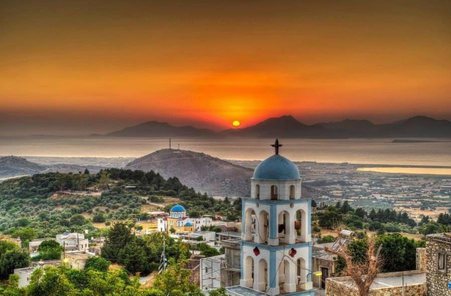 una chiesa con il tramonto sullo sfondo di Seaview Villa ad Asfendioú