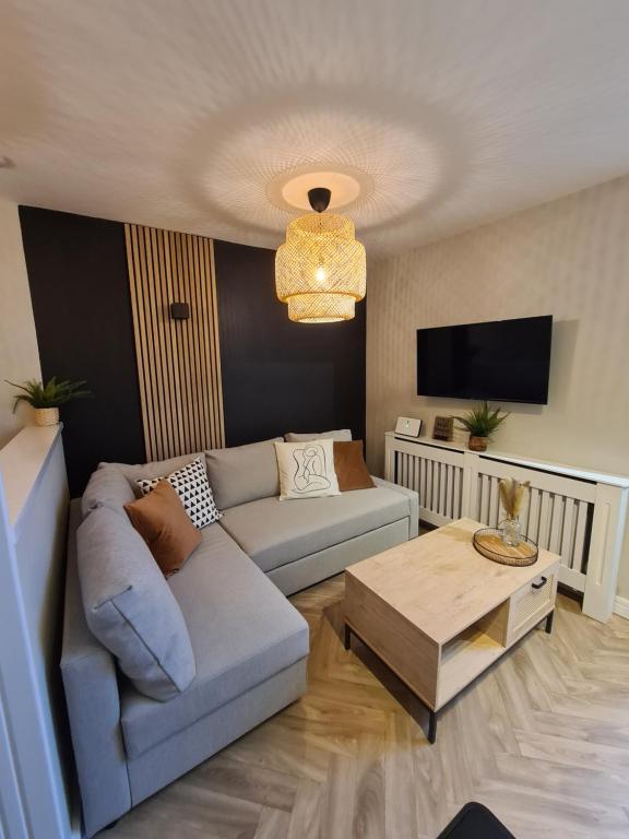 a living room with a couch and a coffee table at Modern 1 bed apartment next to beach and golf course in Llanelli