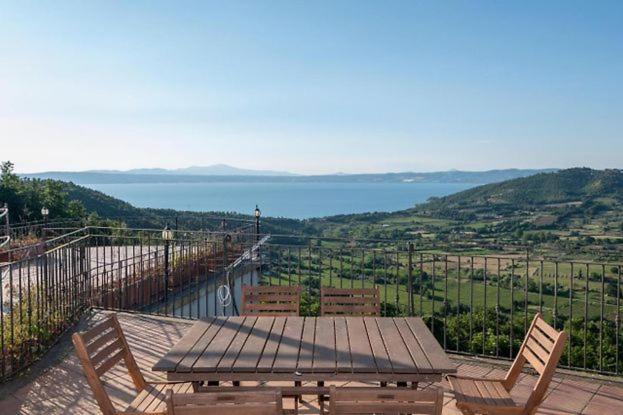 mesa de picnic con sillas y vistas al océano en Casa Vacanze Montedoro, en Montefiascone