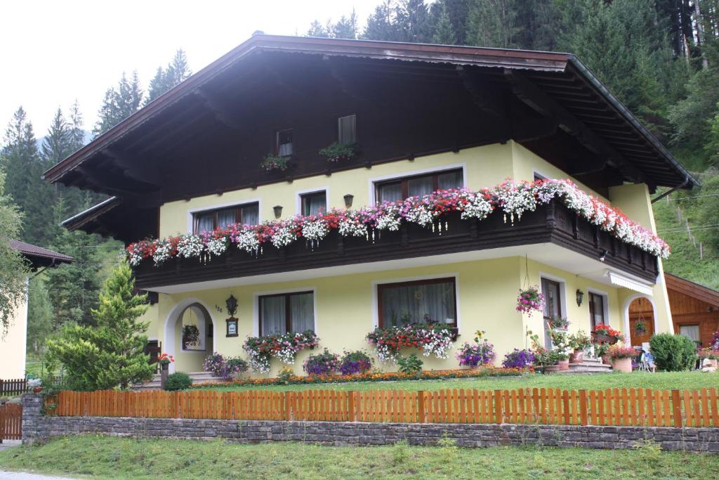 ein Haus mit Blumen auf dem Balkon in der Unterkunft Schwarzenbacher in Lungötz