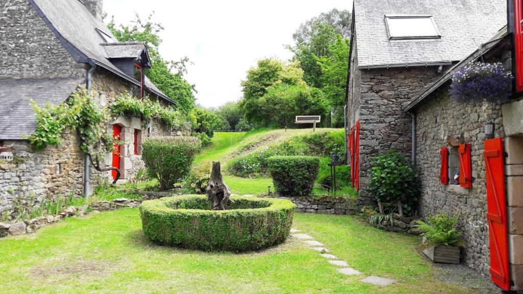 un giardino con una statua in mezzo a un cortile di Maison de contes en amoureux a Taden