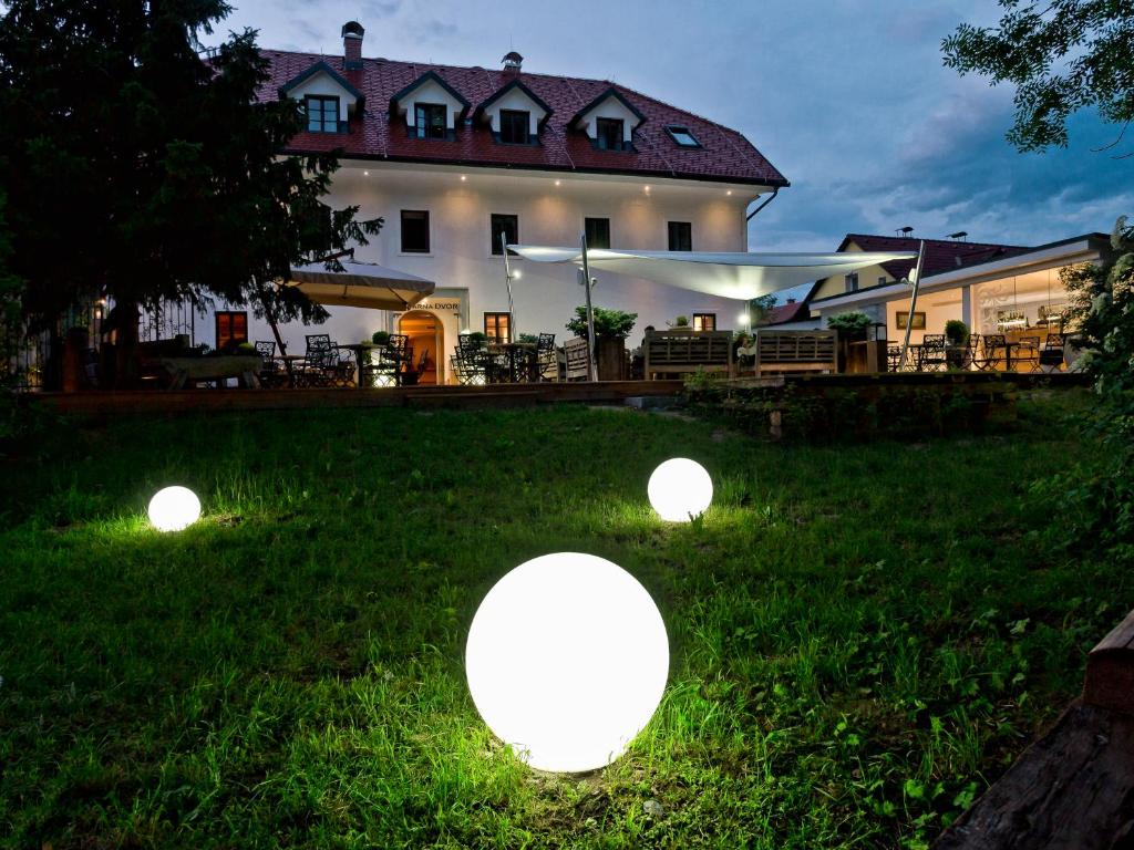 a house with three lights in the grass at B&B Dvor Tacen in Ljubljana
