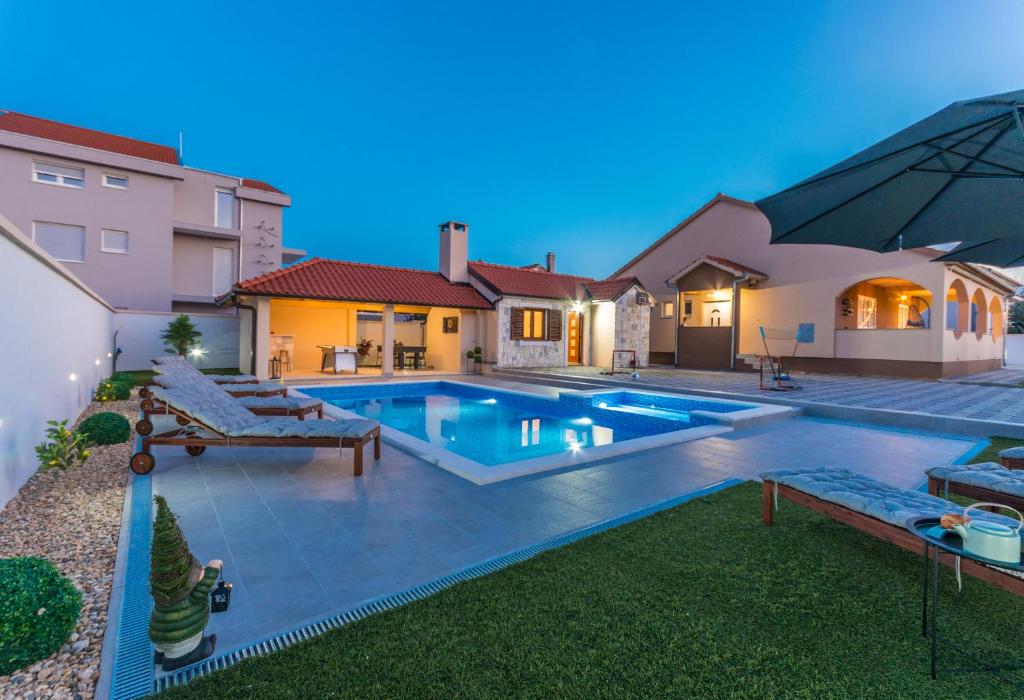 ein Swimmingpool im Hinterhof eines Hauses in der Unterkunft Villa Lucija in Biograd na Moru