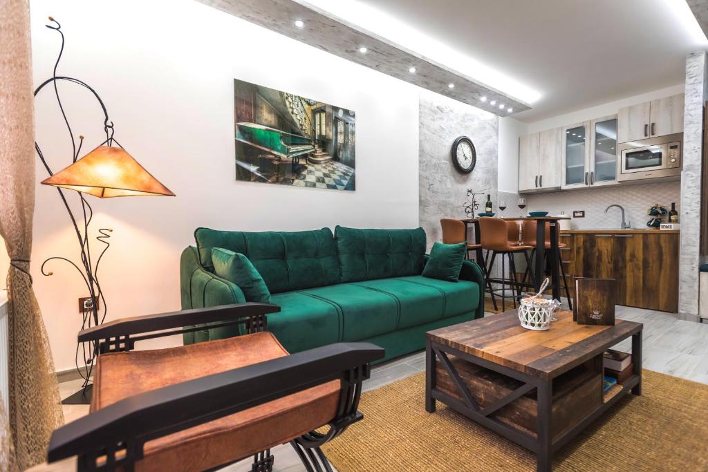 een woonkamer met een groene bank en een tafel bij Apartman Despot in Banja Koviljača