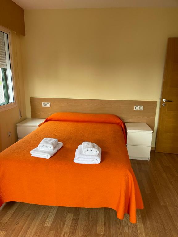 a bedroom with an orange bed with towels on it at Apartment Lecer 7 - 2nd floor in Porta