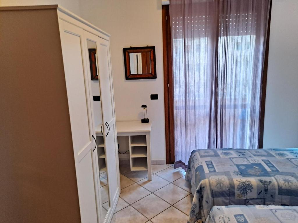 a bedroom with a bed and a table with a mirror at Alghero Heart in Alghero