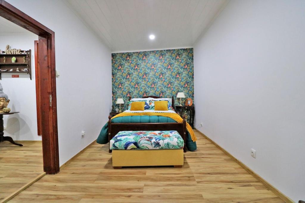 a bedroom with a bed and a wall at Casa 4 Estações in Arrifes