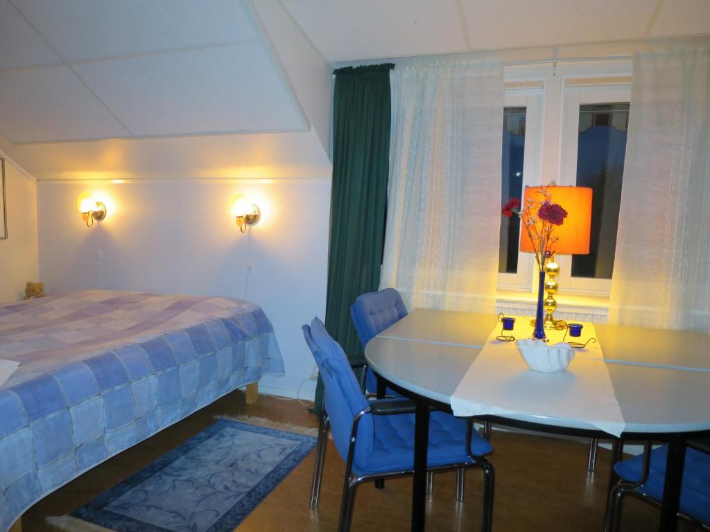 - une chambre avec un lit, une table et des chaises dans l'établissement Dessans Café & Logi, à Pello
