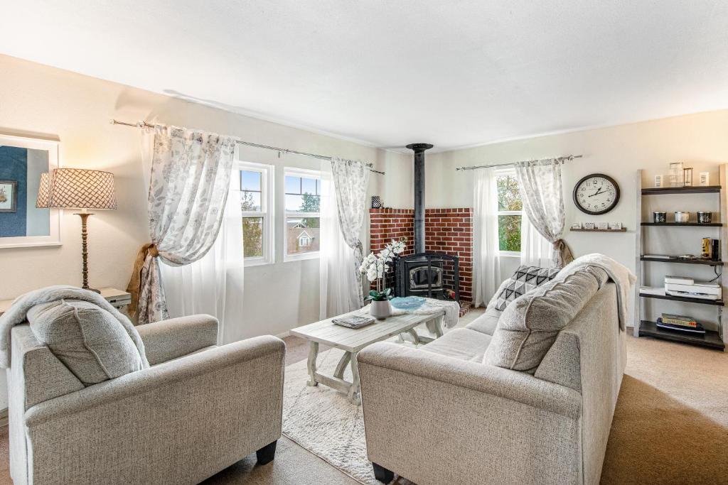 ein Wohnzimmer mit zwei Stühlen und einem Tisch in der Unterkunft Bella Bella Beach Cottage in Gig Harbor