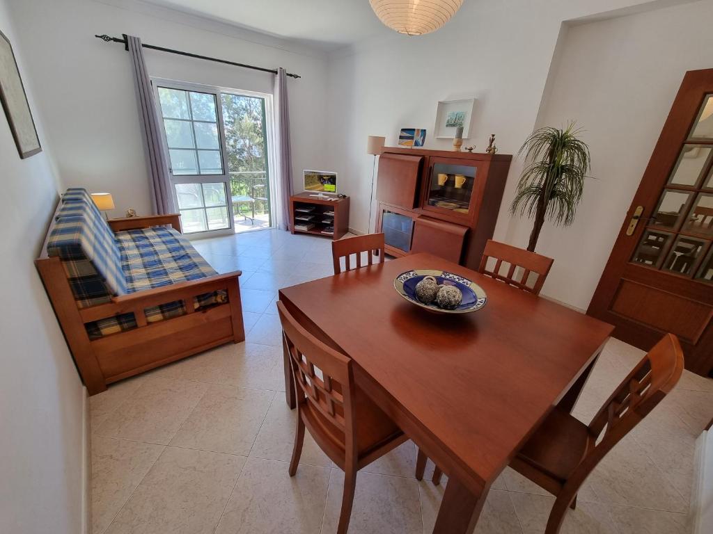 uma sala de jantar com uma mesa de madeira e cadeiras em Apartamento Praia de Altura by Homekeys em Altura