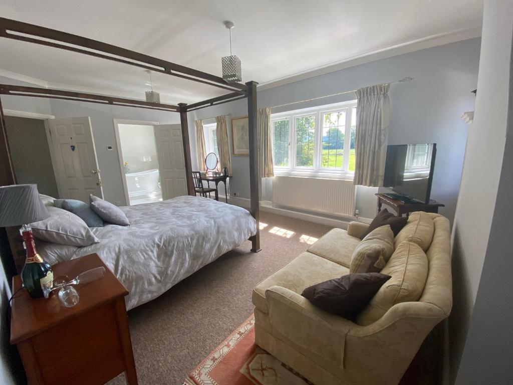 a bedroom with a bed and a couch and a television at Chadwell Hill Farm in Longwick