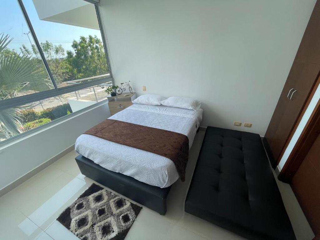 een slaapkamer met een bed en een groot raam bij Condominio Campestre Laguna Club Cartagena in Los Arrayanes