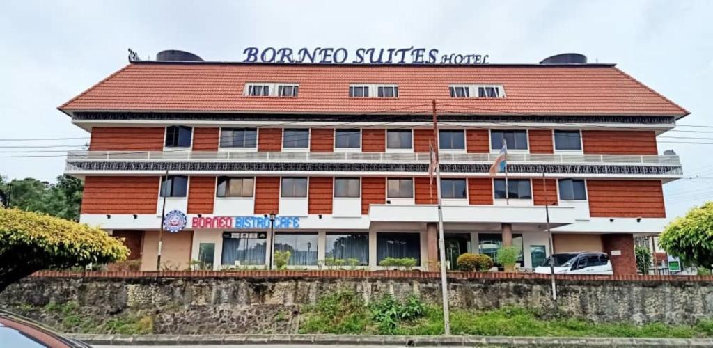 a red and white building with a sign on it at Super OYO 90464 Borneo Suites Hotel in Kota Kinabalu