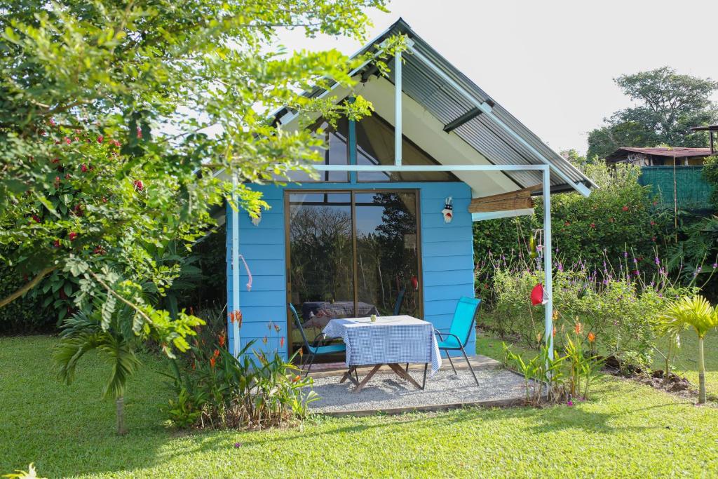 una pequeña casa azul con mesa y sillas en Tiny House Dreamcatcher en Sarchí Sur