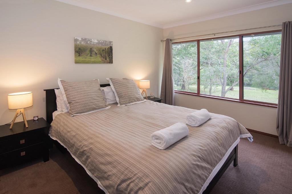 a bedroom with a large bed with two towels on it at Wilyabrup River Retreat- Flutes Estate, Marg River in Wilyabrup