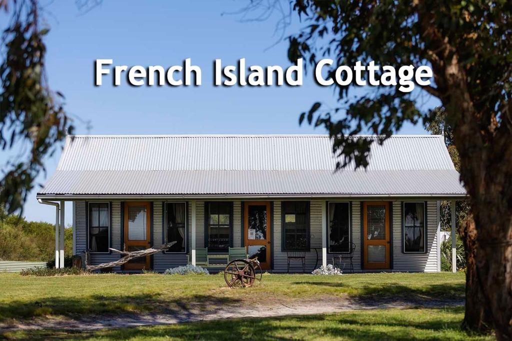 French Island Cottage في Fairhaven: منزل فيه لوحة مكتوب عليها كوخ الجزيرة الفرنسية