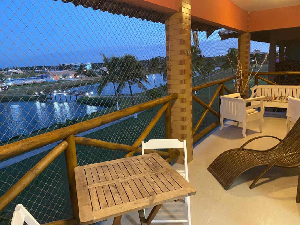 balcón con sillas y vistas al agua en Apartamento em Resort Privativo, en Aracaju
